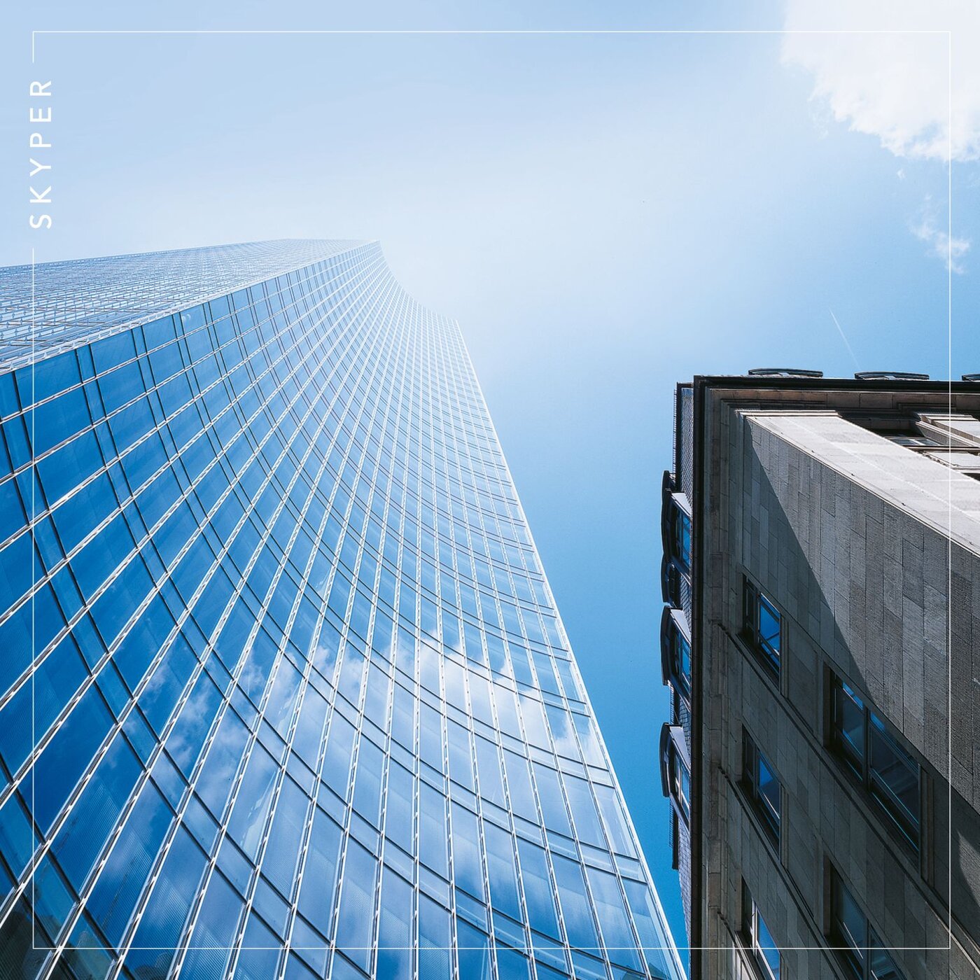 Architekturaufnahme des SKYPER Towers, links, und der historischen Holzmann-Villa (rechts) in Frankfurt am Main mit reflektierender Glasfassade und blauem Himmel