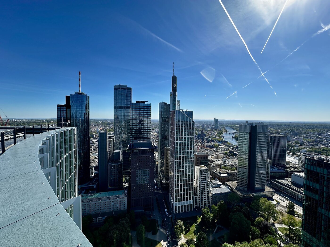 Panoramablick vom SKYPER auf die Frankfurter Skyline mit Hochhäusern, Main und blauem Himmel über dem Bankenviertel.