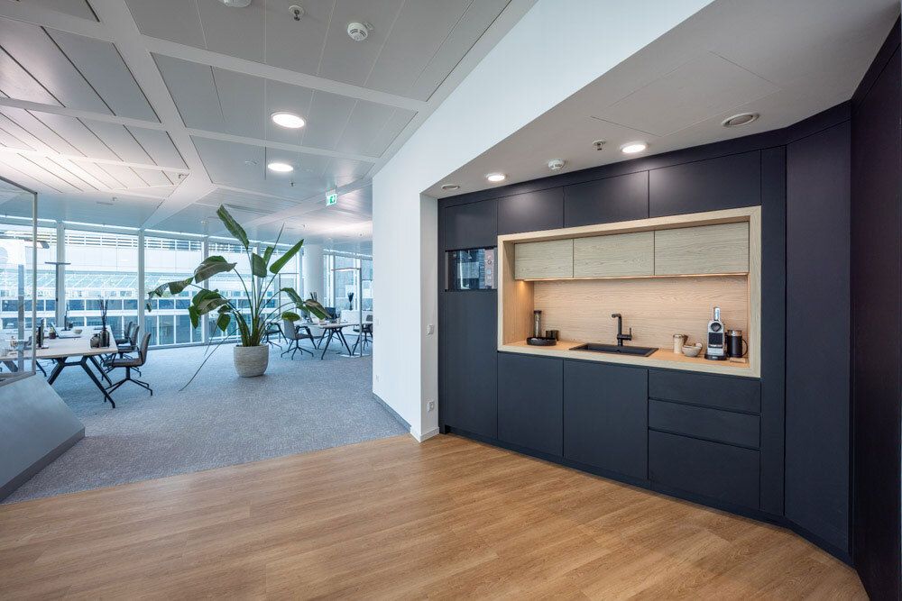 Open kitchenette at SKYPER Frankfurt with adjacent workstations, glass partitions and a flexible office concept designed for collaboration and short distances.